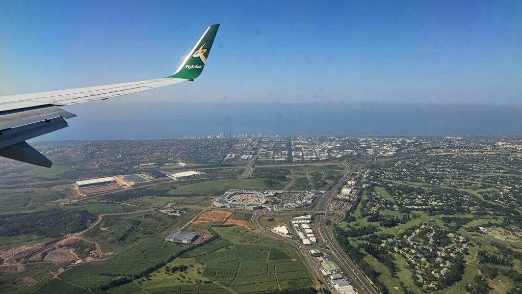 Scenic aerial view of Durban coastline from an airplane, capturing cityscape and landscape.